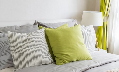 modern bedroom with green pillow on bed